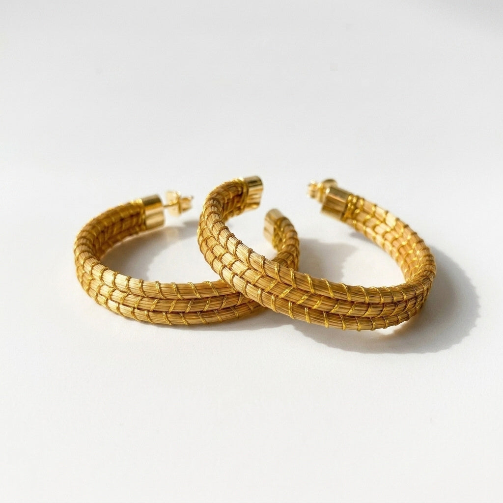 Boucles d'oreilles Embé, créoles ouvertes dorées en or végétal du Brésil, capim dourado tressé à la main, vue trois quarts