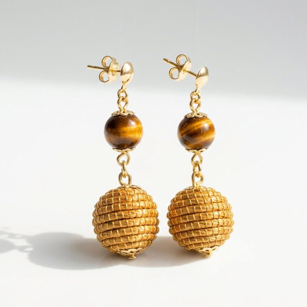 Boucles d'oreilles Jacaré, sphère en or végétal du Brésil et pierre œil de tigre, capim dourado tressé à la main, vue frontale alternative