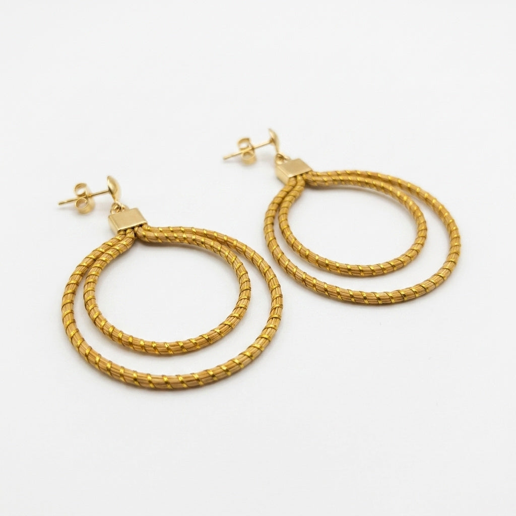 Boucles d'oreilles Nhambu, double anneau doré en or végétal du Brésil, capim dourado tressé à la main, vue trois quarts