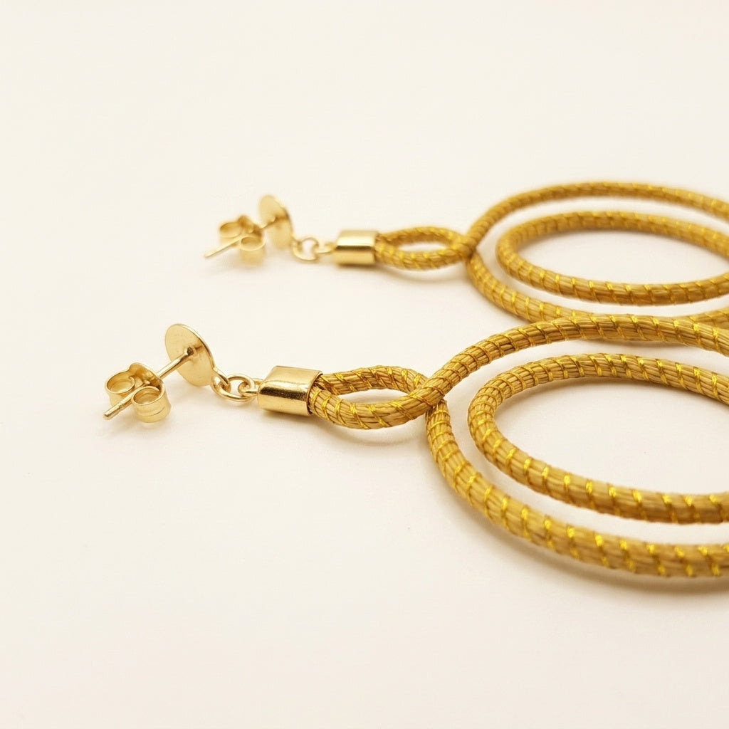 Boucles d'oreilles Urubu, détail du tressage en fibre dorée du Tocantins, gros plan sur la partie supérieure