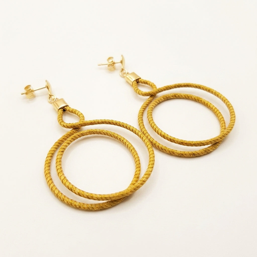 Boucles d'oreilles pendantes artisanales Urubu en or végétal du Brésil, double cercle en capim dourado, vue trois quarts