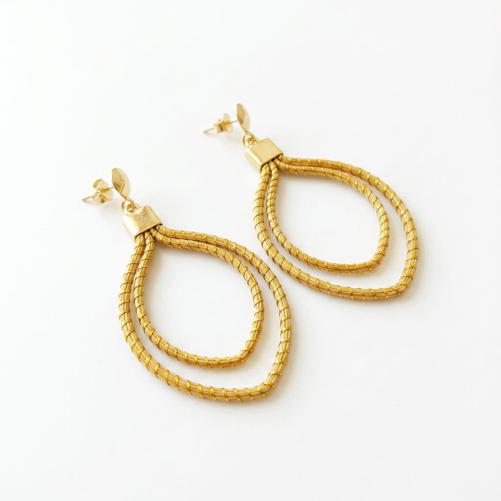 Boucles d'oreilles Curió en capim dourado, double feuille tressée en fibre dorée du Brésil, vue frontale verticale