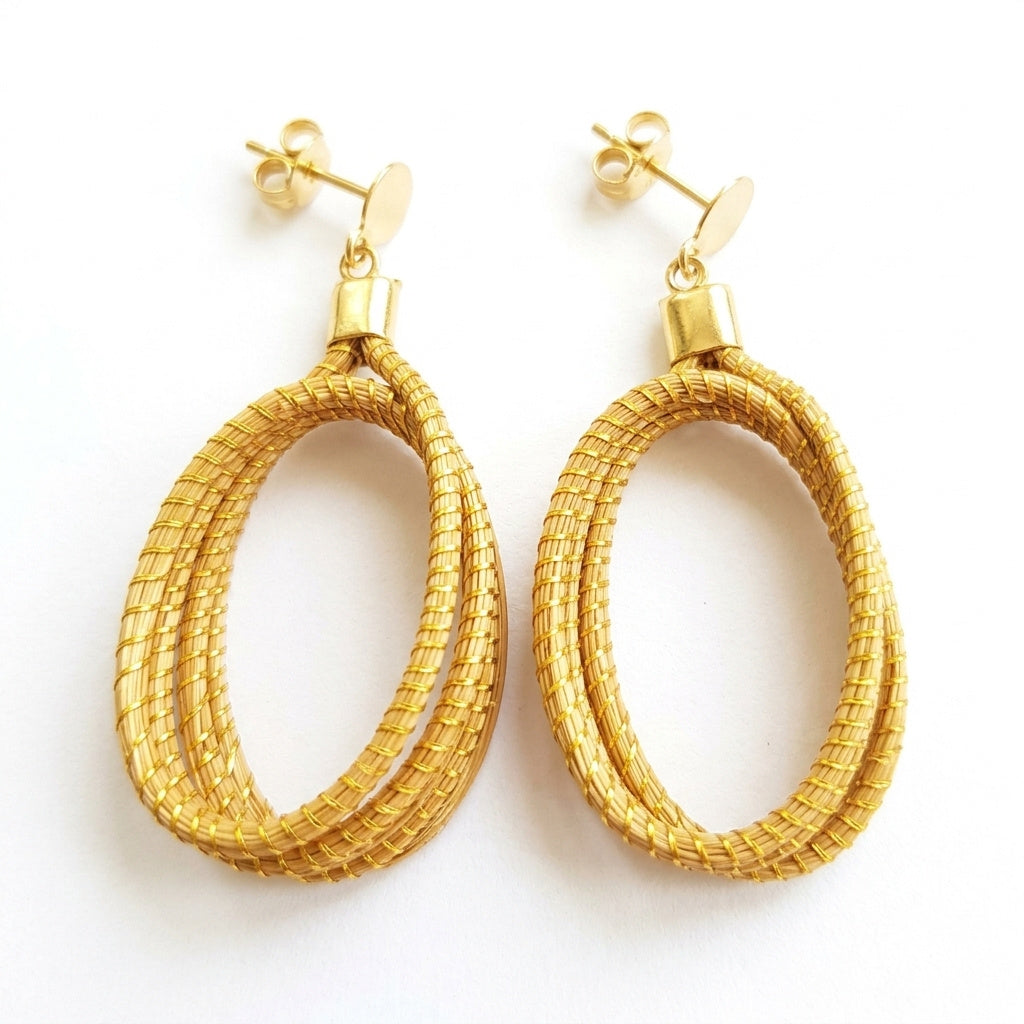 Boucles d'oreilles Guariba en capim dourado, anneaux torsadés tressés en fibre dorée du Brésil, vue frontale verticale