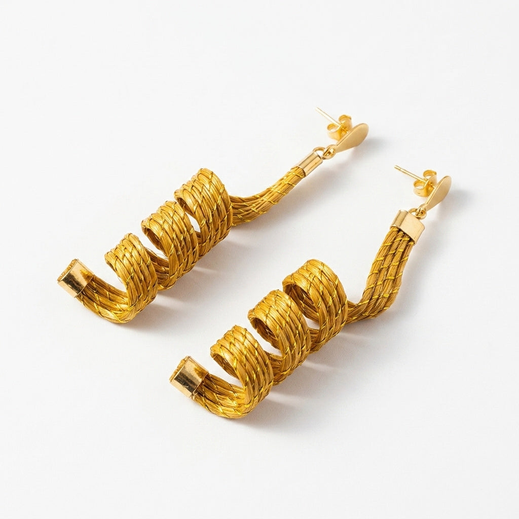 Boucles d'oreilles Guavira, bijou en fibre végétale dorée du Jalapão, design en ressort spirale, vue trois quarts