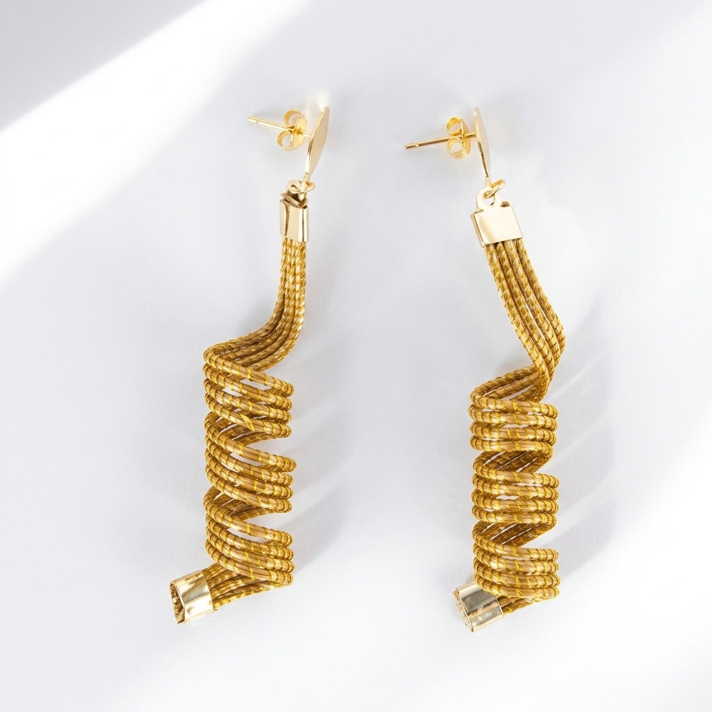 Boucles d'oreilles Guavira en capim dourado, design en vrille spirale tressée en fibre dorée du Brésil, vue frontale