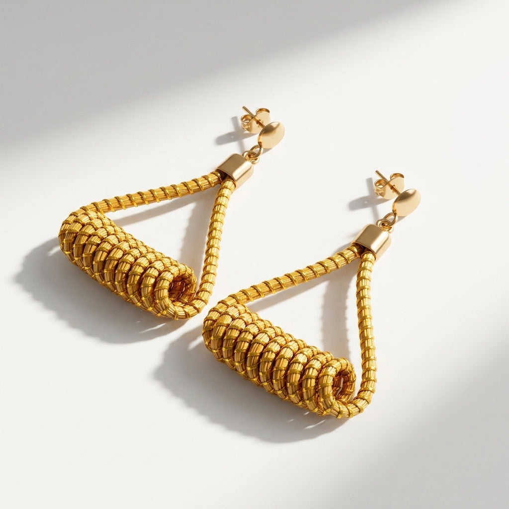 Boucles d'oreilles Matrinxá, bijou géométrique artisanal en herbe dorée, vue à plat avec ombres marquées