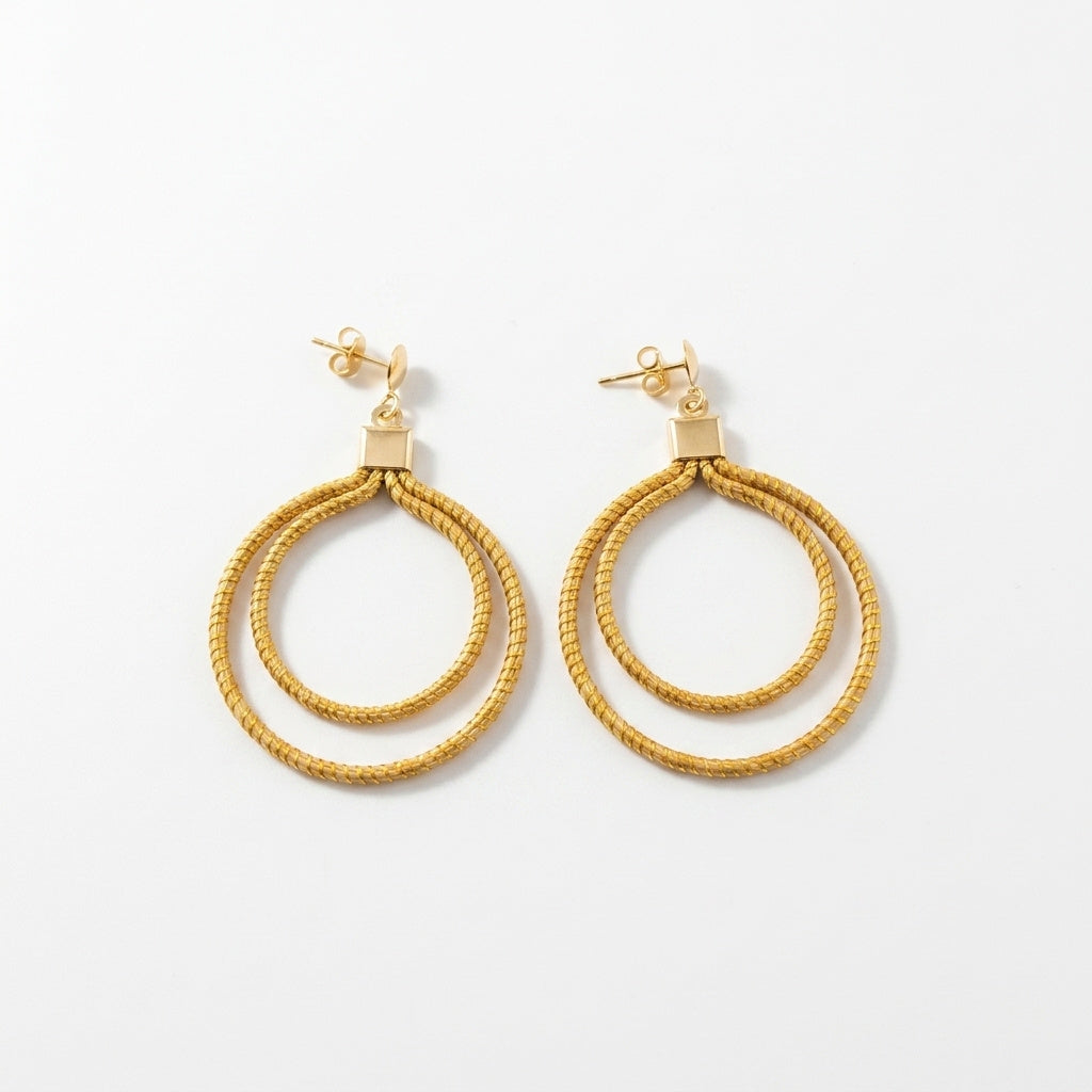 Boucles d'oreilles Nhambu en capim dourado, double anneau tressé en fibre dorée du Brésil, vue frontale verticale