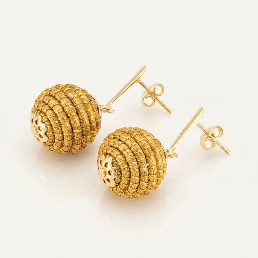 Boucles d'oreilles Poranga, bijou végétal doré artisanal, détail des sphères tressées en fibre dorée du Tocantins
