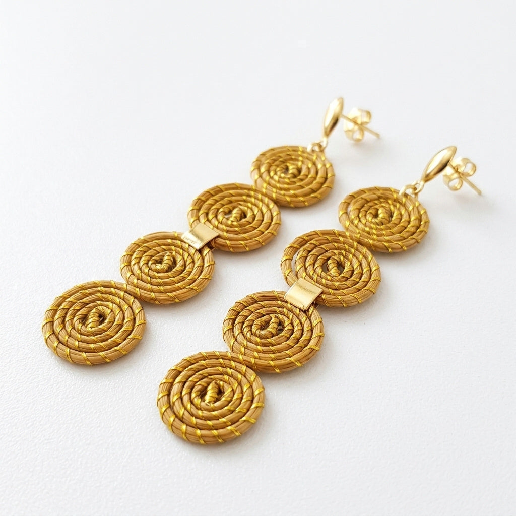 Boucles d'oreilles Taquara, artisanat brésilien fait main en herbe dorée, vue trois quarts avec ombre douce