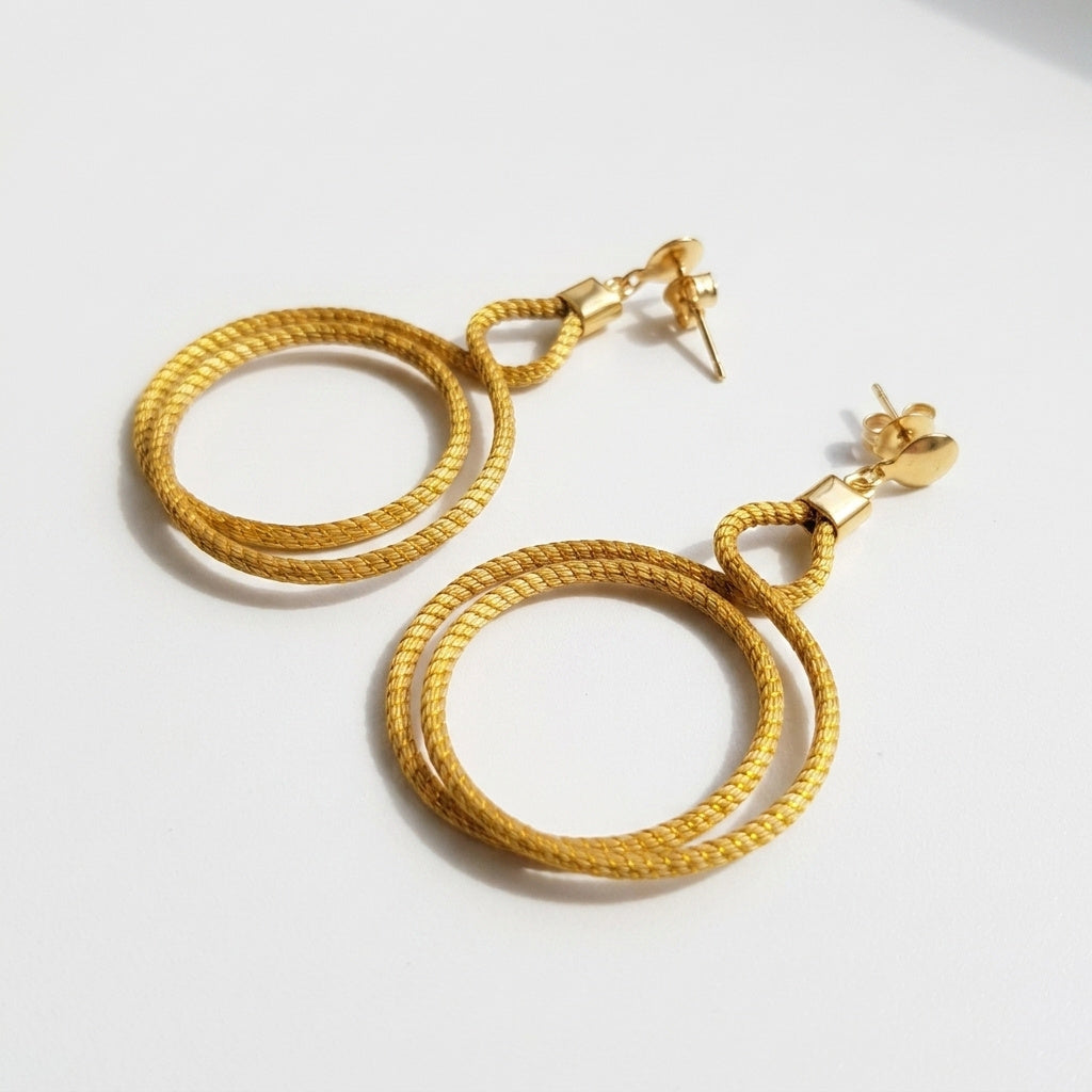 Boucles d'oreilles Urubu, bijou naturel doré du Jalapão, double cercle artisanal, vue trois quarts alternative
